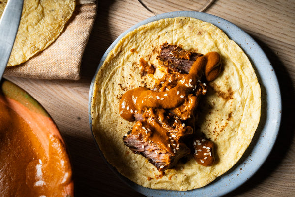 Un taco de costilla con mole en un plato