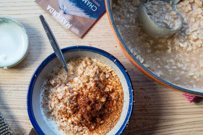 Bowl of Arroz con Leche with Champurrado garnished with champurrado mix and sweet crema